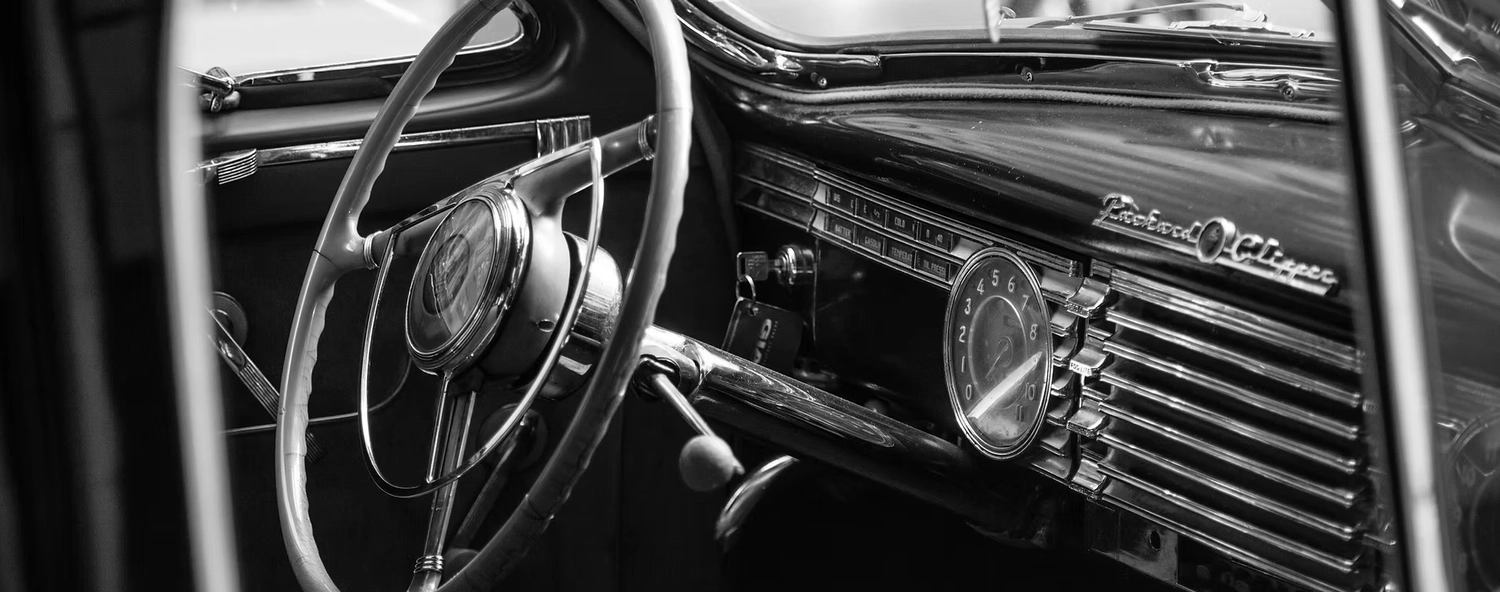 Fahrschule Fahrwerk Bayer GmbH - Führerscheinausbildung - Das Armaturenbrett und das Lenkrad eines klassischen Packard Clipper Automobils.